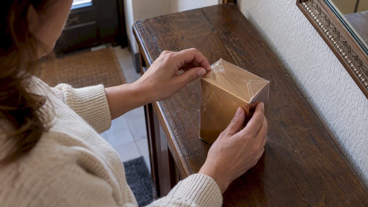 Manos revisando el celofán de una caja